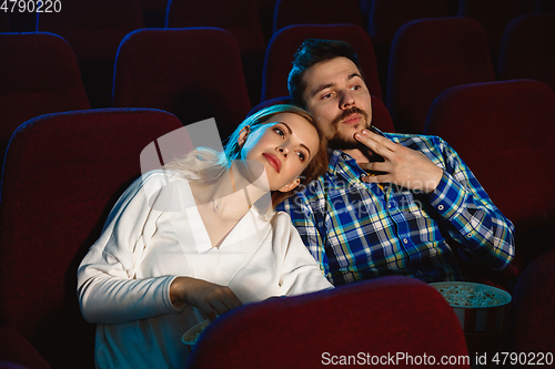 Image of Attractive young caucasian couple watching a film at a movie theater