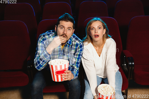 Image of Attractive young caucasian couple watching a film at a movie theater