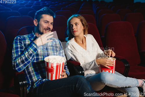 Image of Attractive young caucasian couple watching a film at a movie theater