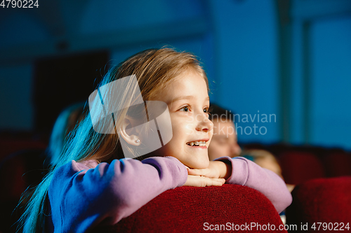 Image of Young caucasian family watching a film at a movie theater