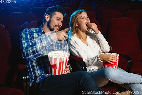 Image of Attractive young caucasian couple watching a film at a movie theater