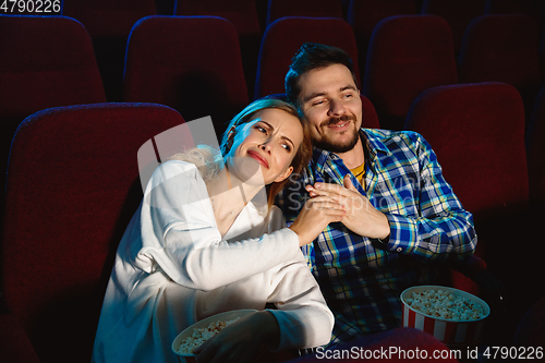 Image of Attractive young caucasian couple watching a film at a movie theater