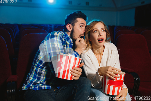 Image of Attractive young caucasian couple watching a film at a movie theater