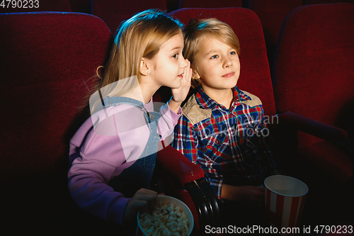 Image of Little girl and boy watching a film at a movie theater