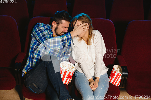 Image of Attractive young caucasian couple watching a film at a movie theater