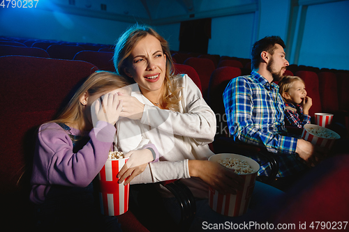 Image of Young caucasian family watching a film at a movie theater