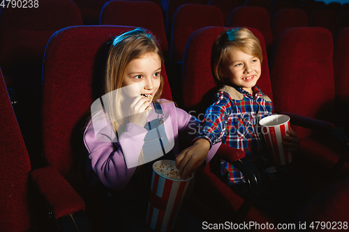 Image of Little girl and boy watching a film at a movie theater