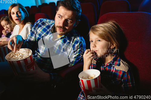 Image of Young caucasian family watching a film at a movie theater