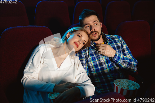 Image of Attractive young caucasian couple watching a film at a movie theater