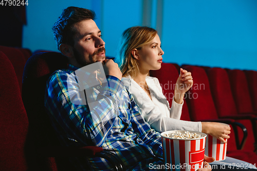 Image of Attractive young caucasian couple watching a film at a movie theater