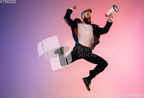 Image of Full length portrait of happy jumping man in neon light and gradient background