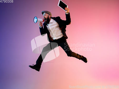 Image of Full length portrait of happy jumping man in neon light and gradient background