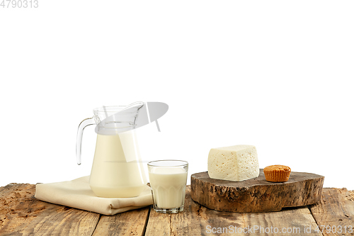 Image of Different milk products, cheese, cream, milk on wooden table and white background.