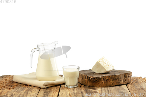 Image of Different milk products, cheese, cream, milk on wooden table and white background.