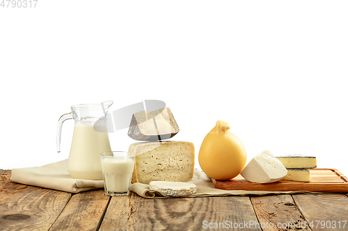 Image of Different milk products, cheese, cream, milk on wooden table and white background.