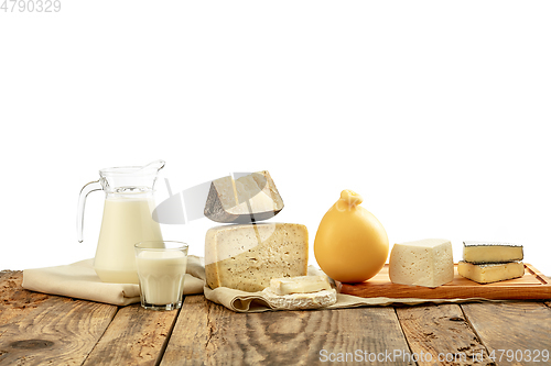 Image of Different milk products, cheese, cream, milk on wooden table and white background.