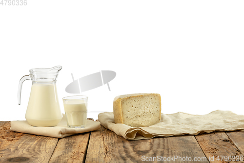 Image of Different milk products, cheese, cream, milk on wooden table and white background.