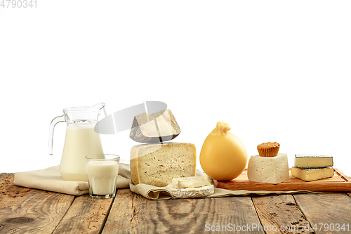 Image of Different milk products, cheese, cream, milk on wooden table and white background.