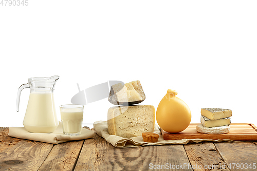 Image of Different milk products, cheese, cream, milk on wooden table and white background.