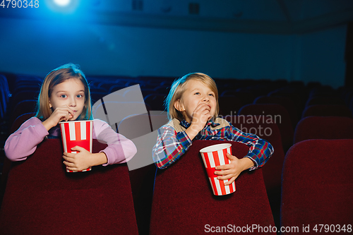 Image of Little girl and boy watching a film at a movie theater