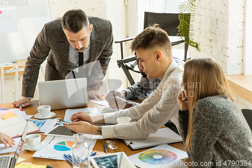 Image of Group of young business professionals having a meeting, creative office