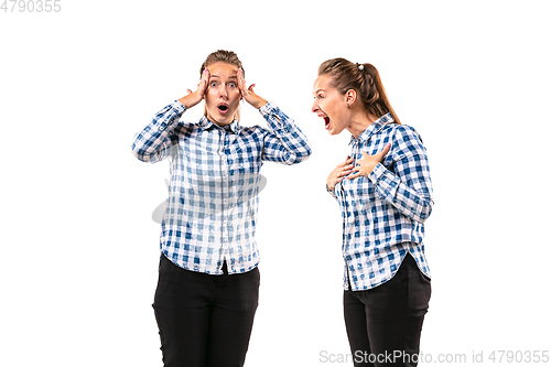 Image of Young handsome woman arguing with herself on white studio background.