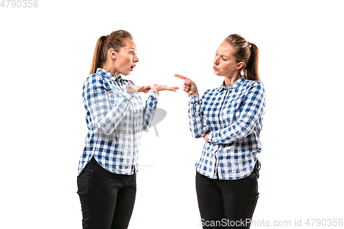 Image of Young handsome woman arguing with herself on white studio background.