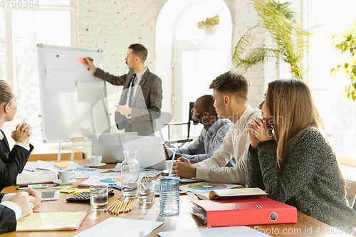 Image of Group of young business professionals having a meeting, creative office