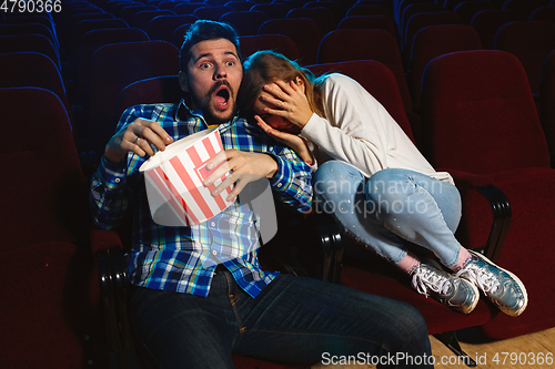 Image of Attractive young caucasian couple watching a film at a movie theater