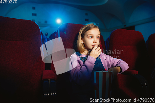 Image of Little girl watching a film at a movie theater