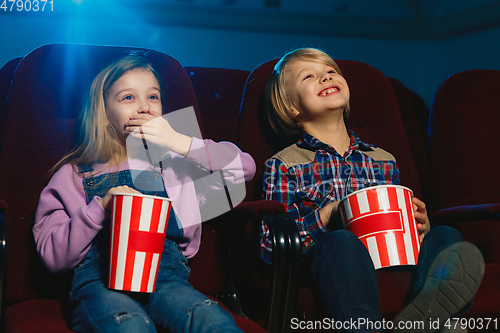 Image of Little girl and boy watching a film at a movie theater