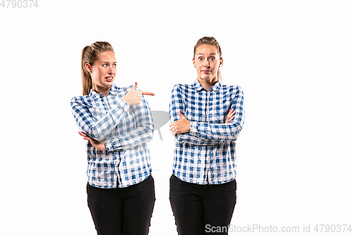 Image of Young handsome woman arguing with herself on white studio background.