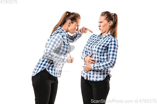 Image of Young handsome woman arguing with herself on white studio background.