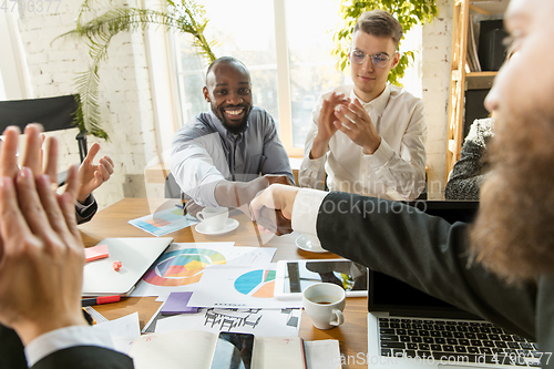 Image of Group of young business professionals having a meeting, creative office