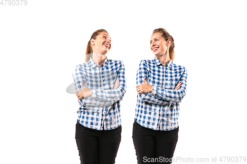 Image of Young handsome woman arguing with herself on white studio background.