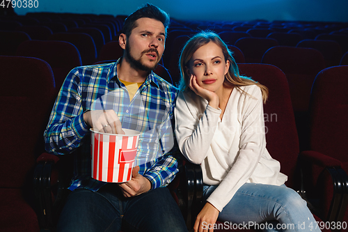 Image of Attractive young caucasian couple watching a film at a movie theater