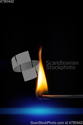 Image of match stick flame in front of a black background