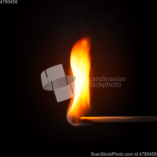 Image of match stick flame in front of a black background