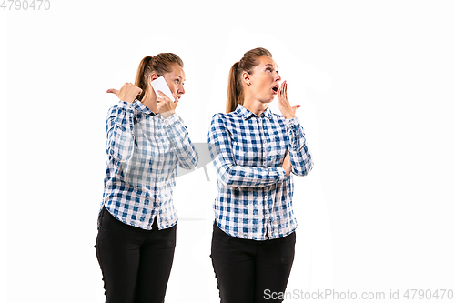 Image of Young handsome woman arguing with herself on white studio background.