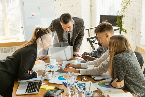 Image of Group of young business professionals having a meeting, creative office