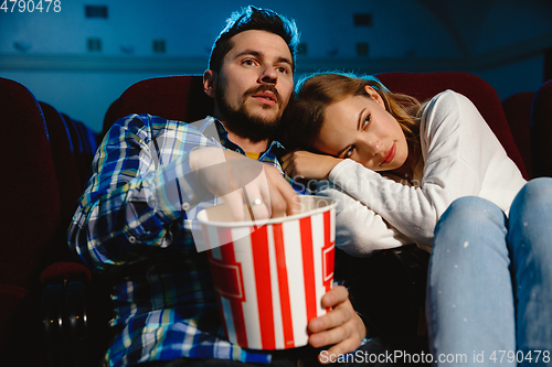 Image of Attractive young caucasian couple watching a film at a movie theater