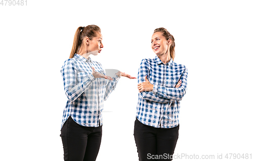 Image of Young handsome woman arguing with herself on white studio background.