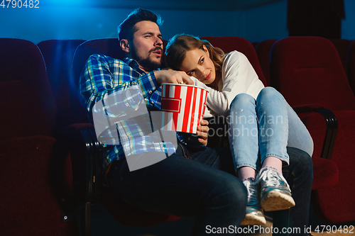 Image of Attractive young caucasian couple watching a film at a movie theater