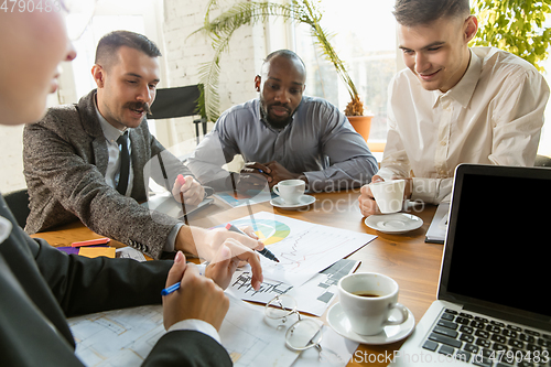 Image of Group of young business professionals having a meeting, creative office