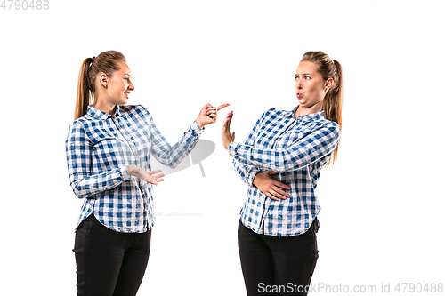 Image of Young handsome woman arguing with herself on white studio background.