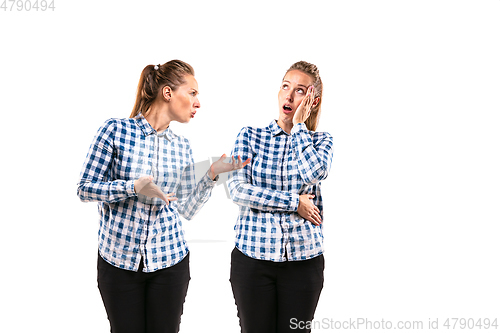 Image of Young handsome woman arguing with herself on white studio background.