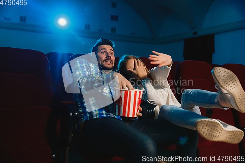 Image of Attractive young caucasian couple watching a film at a movie theater