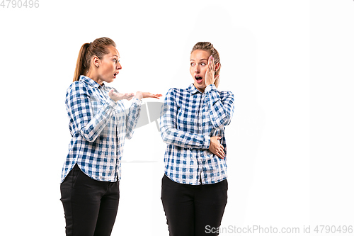 Image of Young handsome woman arguing with herself on white studio background.