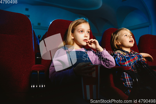 Image of Little girl and boy watching a film at a movie theater