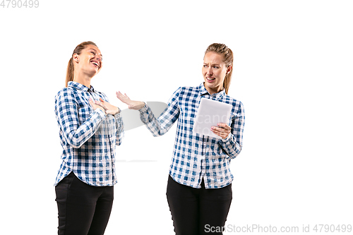 Image of Young handsome woman arguing with herself on white studio background.